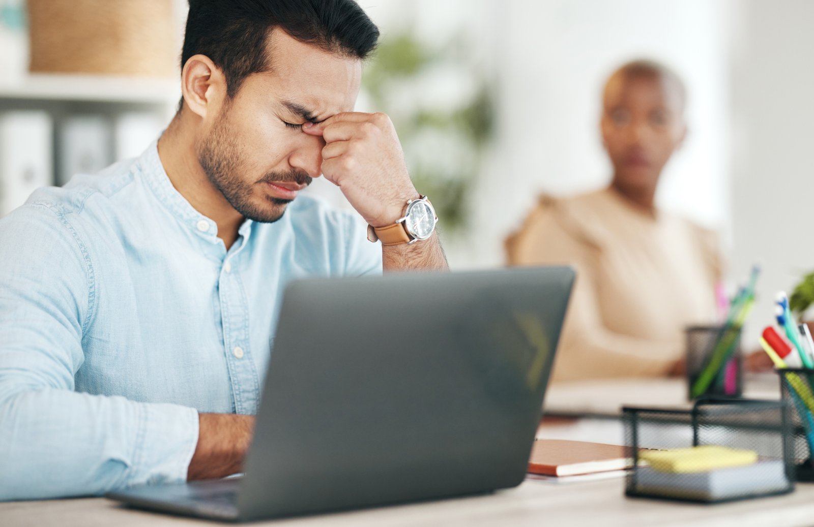 Stress headache, burnout and Indian man exhausted, overwhelmed with workload deadline in office. Fr.