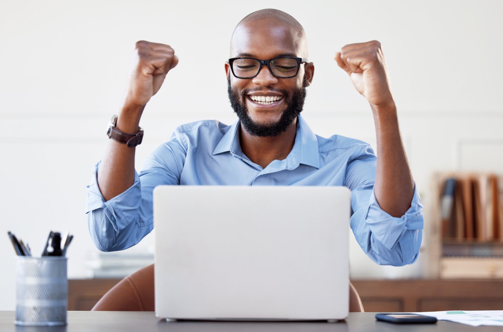 I did it again. Shot of a businessman looking cheerful while working on his laptop in his office